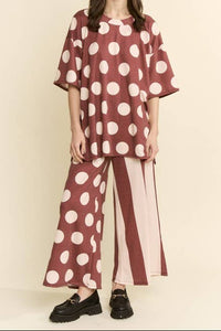Woman wearing a polka dot outfit with a plain background