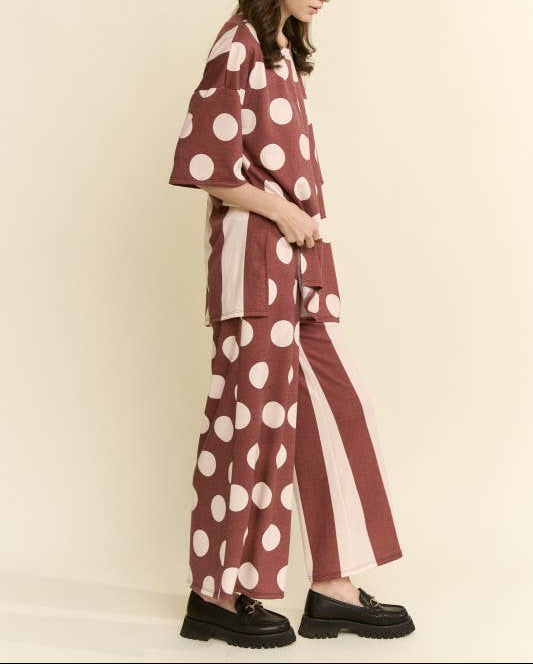Person wearing a polka dot outfit with a beige background